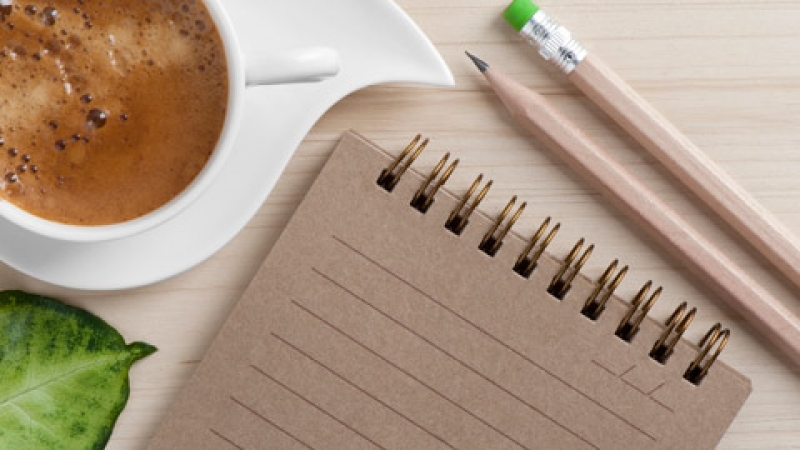 Coffee cup, notepad and pencils